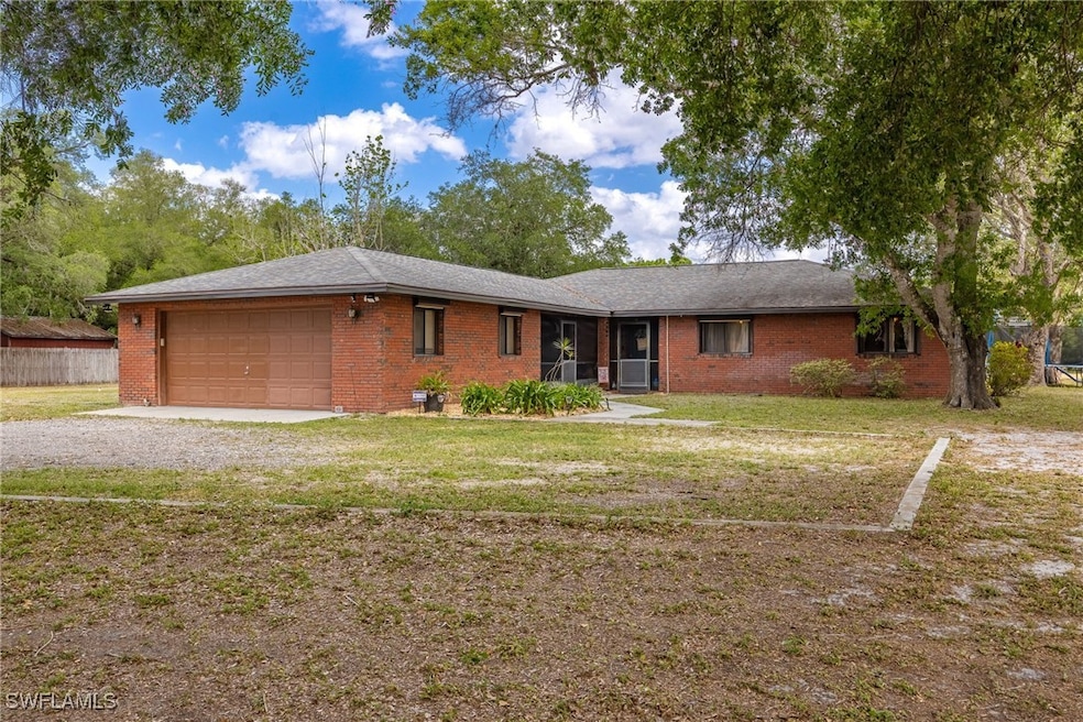 Ranch-style house with brick siding, driveway, a f