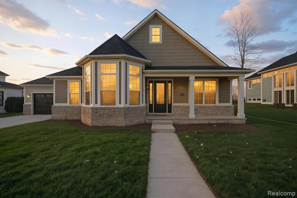 View of front of home with covered porch, a lawn, driveway, and a garage