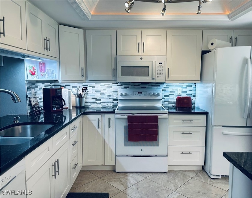 Kitchen featuring white appliances, a tray ceiling