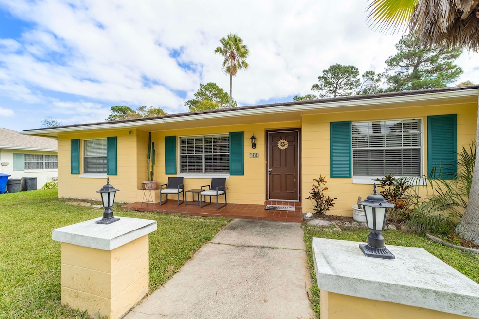 Bungalow-style house with concrete block siding and a front lawn
