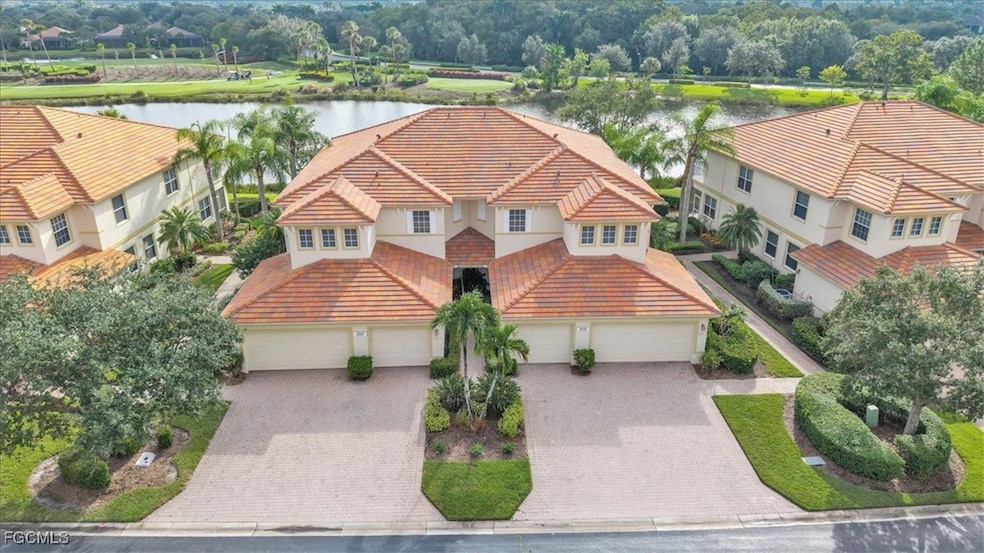 View of front of home with a tile roof, stucco siding, and a water view