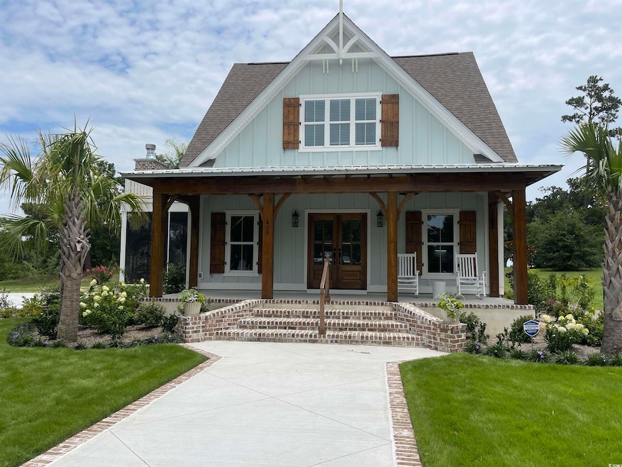 View of front of property featuring a shingled roof, board and batten siding, a porch, french doors, and a front yard