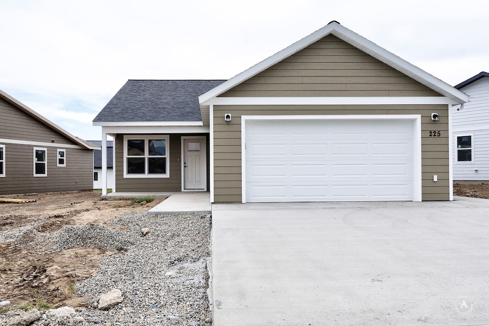 Ranch-style home featuring a shingled roof and driveway