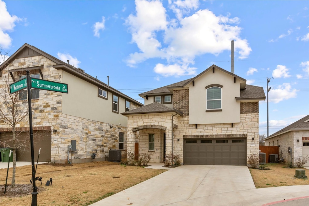 View of front facade featuring stone siding, a sh