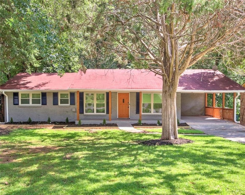 Ranch-style home with a carport, brick siding, driveway, and a front yard