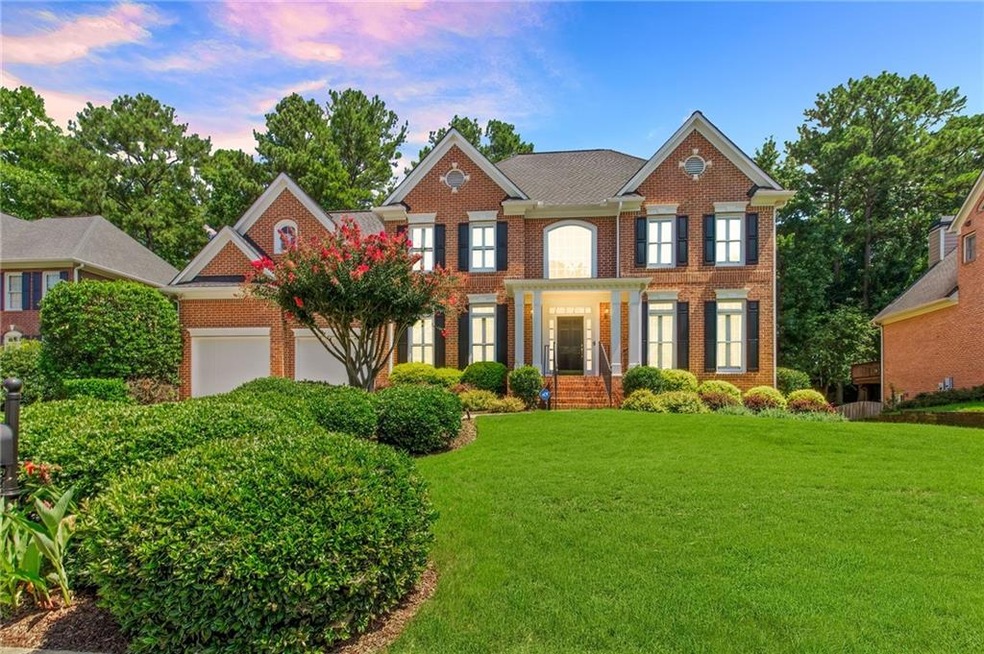 Colonial inspired home featuring a garage and a ya