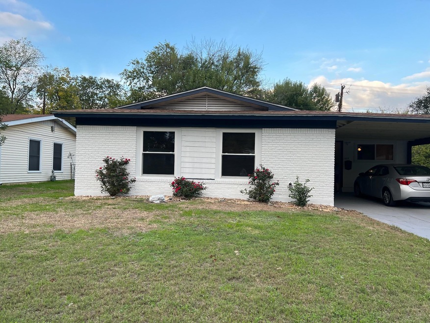 View of front facade featuring a carport, drivewa
