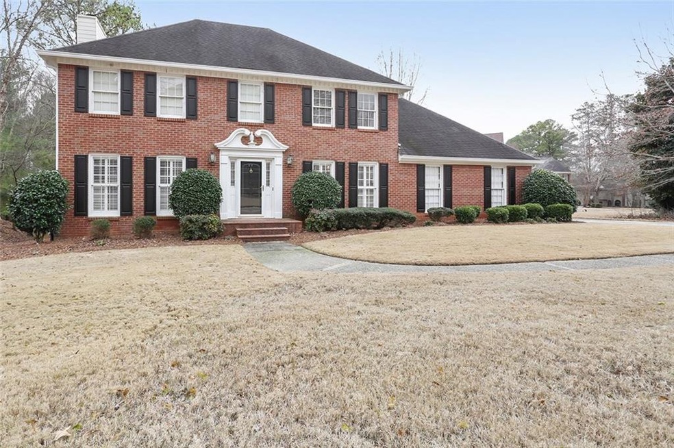 Welcoming brick front exterior with large flat lot