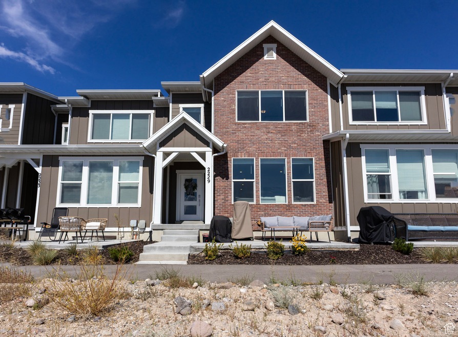 Front of home featuring an outdoor hangout area, board and batten siding, and brick siding