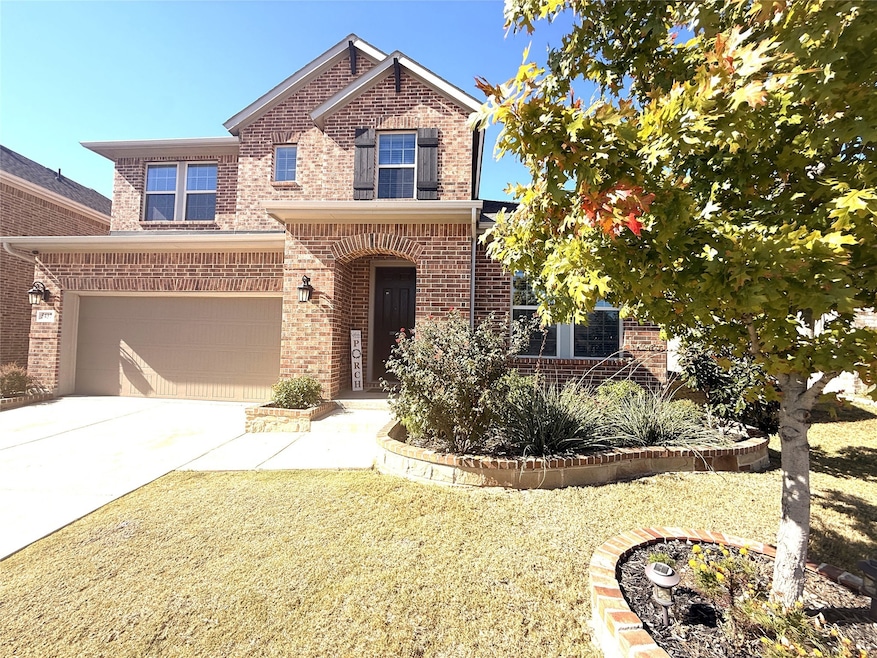 Traditional-style house featuring brick siding, driveway, and a garage