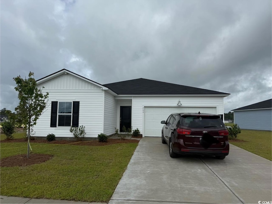 Ranch-style home featuring concrete driveway, an attached garage, and a front lawn