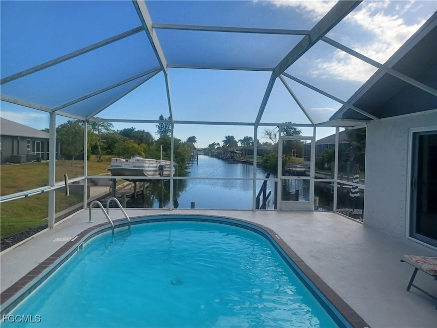 Outdoor pool featuring a sunroom, a water view, a lanai, and a patio area