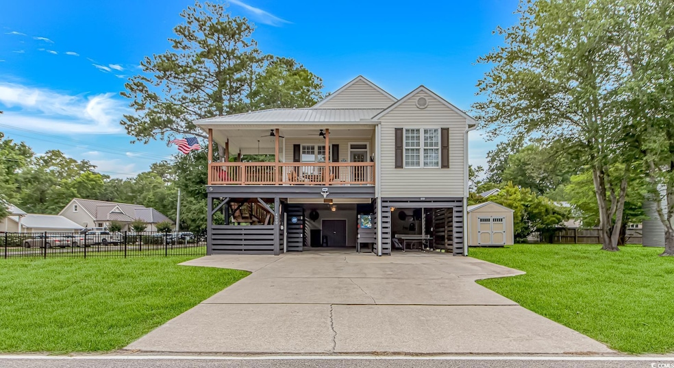 Coastal home featuring a carport, ceiling fan, stairs, a porch, and driveway