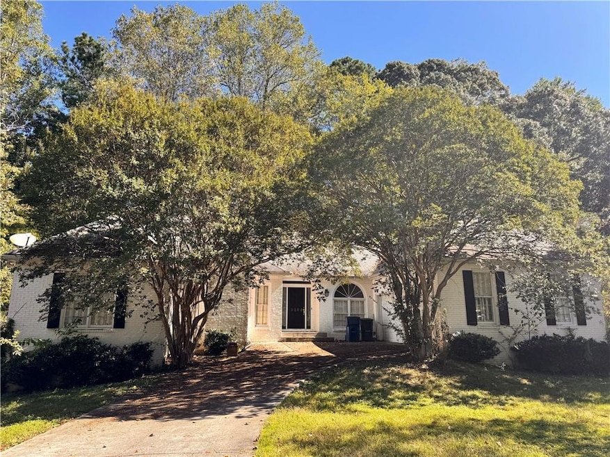 Obstructed view of property with brick siding and a front yard