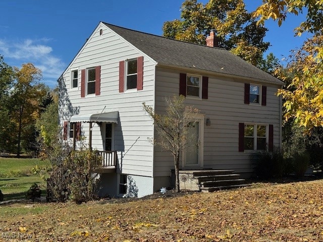 Colonial-style house featuring a chimney