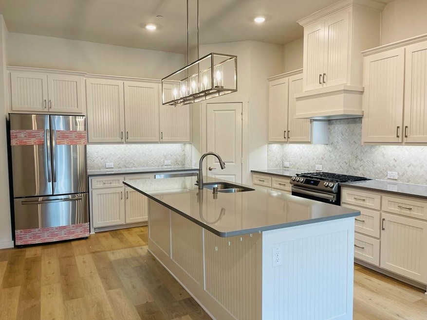Kitchen featuring appliances with stainless steel finishes, light wood-type flooring, backsplash, decorative light fixtures, and recessed lighting