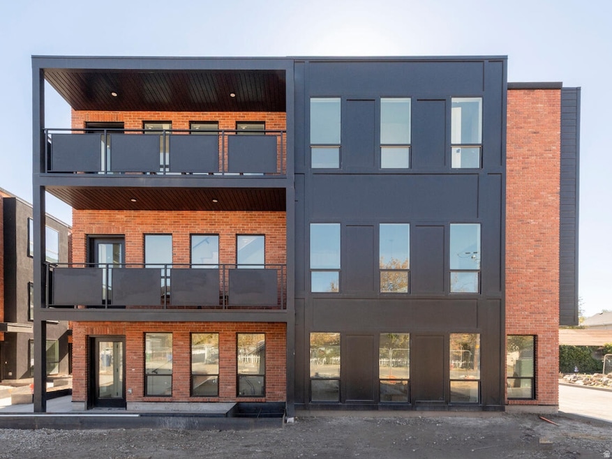 Back of house with brick siding and a balcony