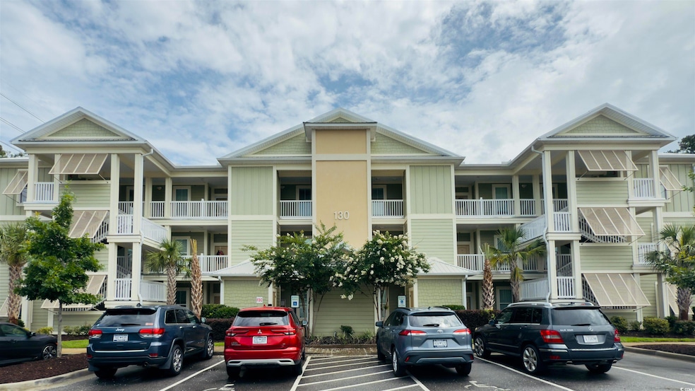 View of apartment building / complex with uncovered parking
