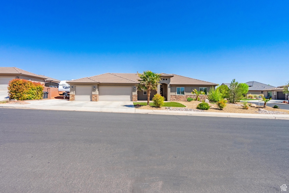 Single story home featuring stucco siding, driveway, a tiled roof, and a garage