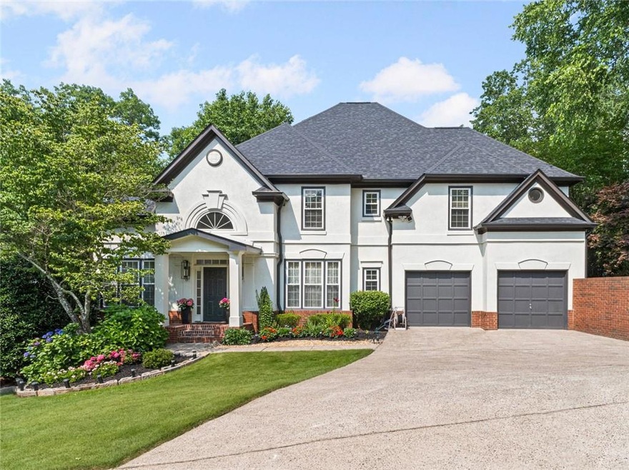 French country inspired facade with driveway, stucco siding, a front lawn, roof with shingles, and a garage
