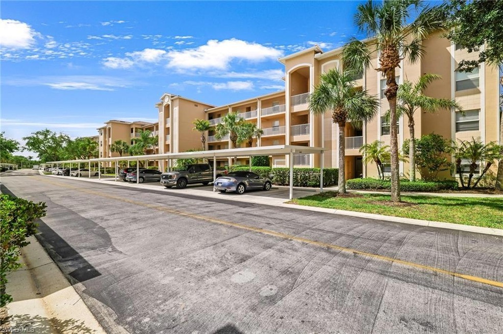 View of apartment building / complex with covered 