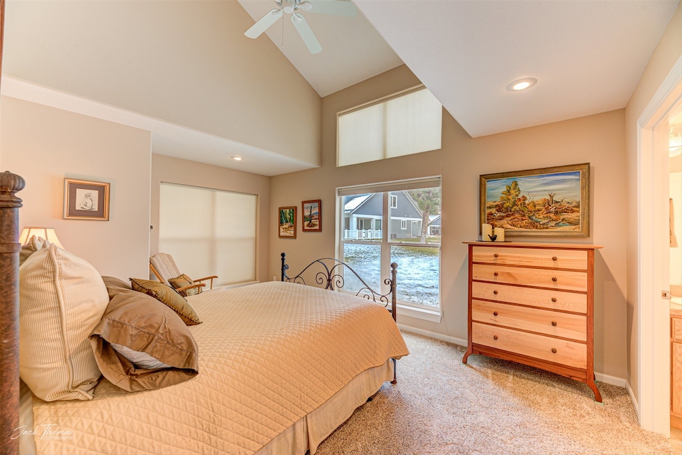 Carpeted bedroom with access to exterior, a towering ceiling, and ceiling fan