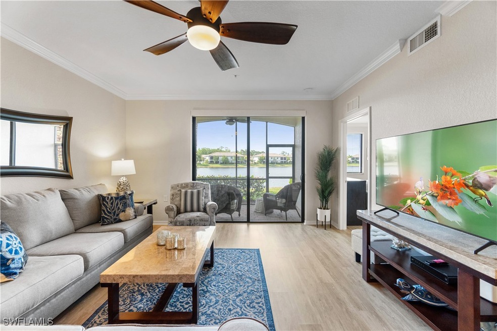 Living room with crown molding, ceiling fan, a wat