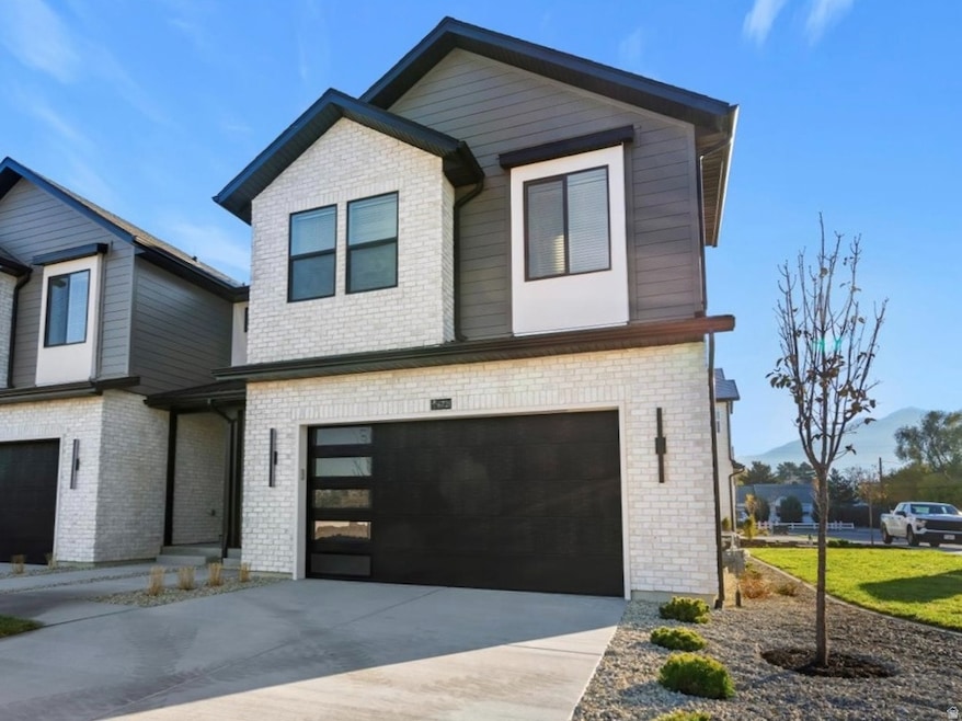 Contemporary home with concrete driveway, brick siding, and a garage