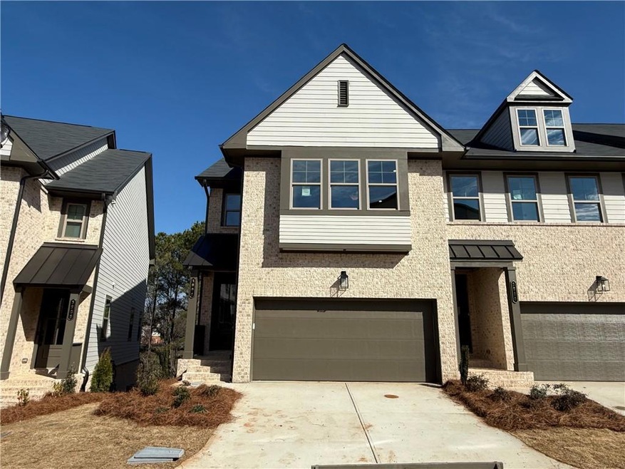 View of property with a garage, driveway, and brick siding