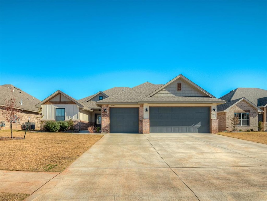 Craftsman-style home featuring driveway, board and batten siding, roof with shingles, a garage, and brick siding