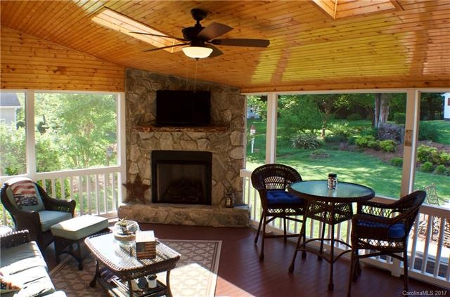 Gorgeous custom screen porch. Stone fireplace with