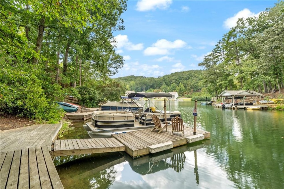 View of dock with a water view and a view of trees