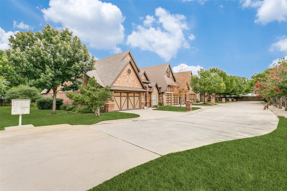 Tudor house featuring a front yard, stone siding, roof with shingles, concrete driveway, and a garage