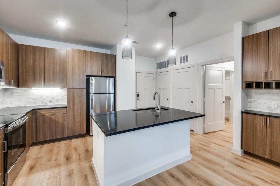 Kitchen with brown cabinets, light wood-style floo