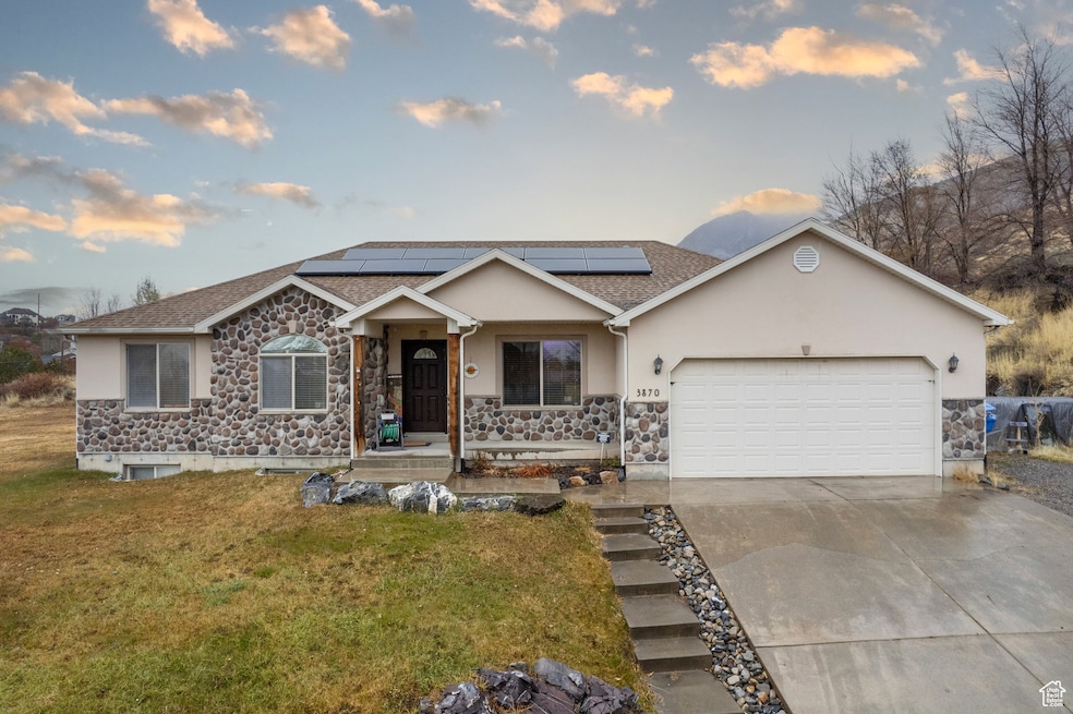 Ranch-style house featuring stone siding, an attached garage, concrete driveway, stucco siding, and a shingled roof