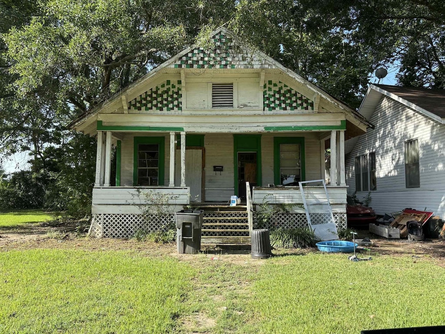 View of front of property featuring a porch and a front yard