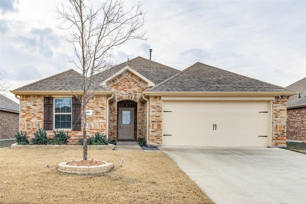 View of front of home with a shingled roof, a front yard, driveway, and brick siding