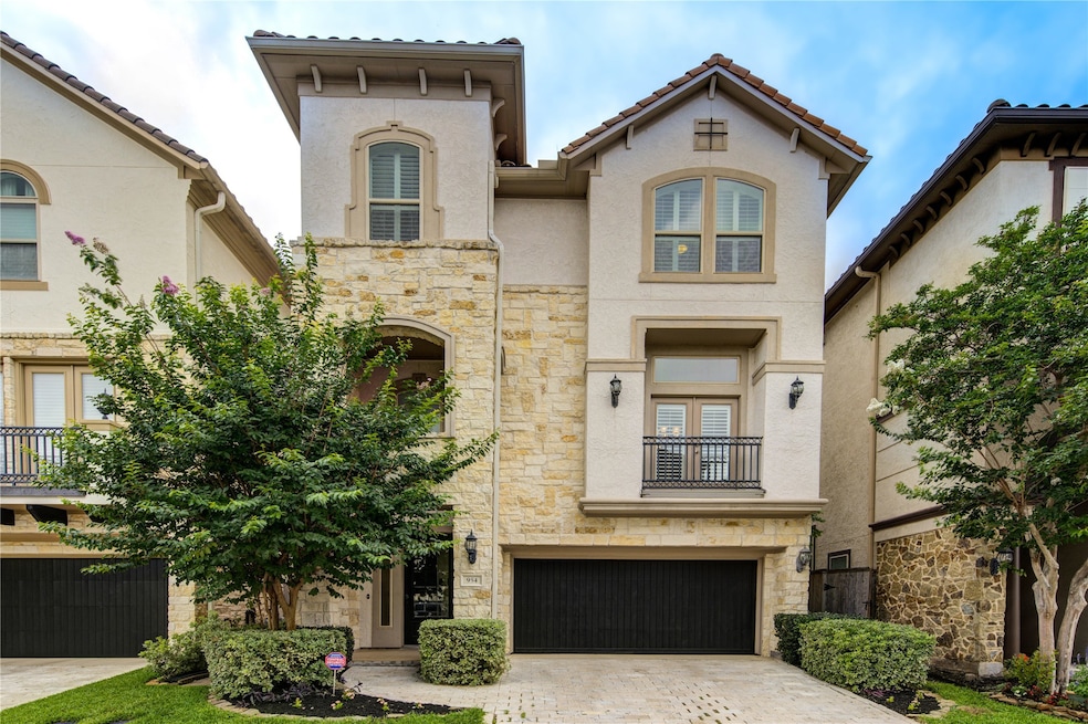 This is a modern, three-story home with a stone an
