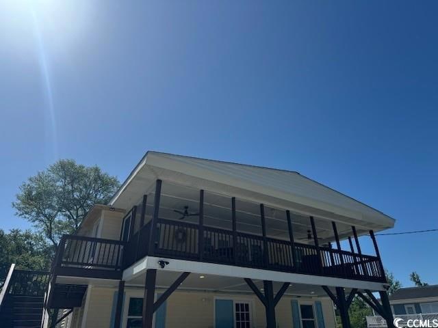 Rear view of property featuring a ceiling fan, stairway, and a wooden deck