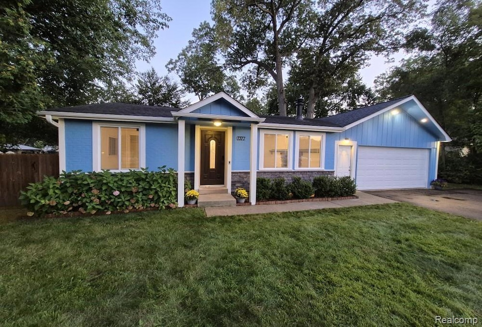 Single story home featuring a garage, driveway, and roof with shingles