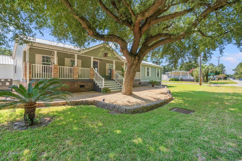 View of front of home featuring a porch, crawl space, a front lawn, and a metal roof