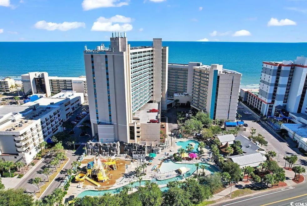 Aerial view featuring a city view and a water view