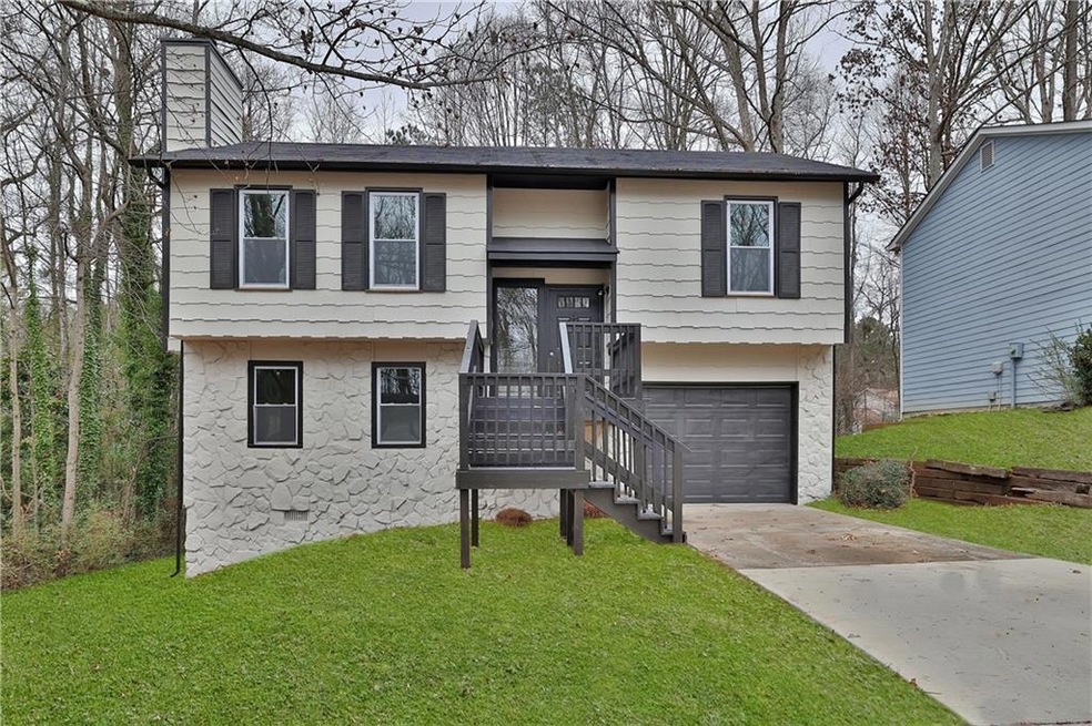 Raised ranch featuring a front lawn and a garage