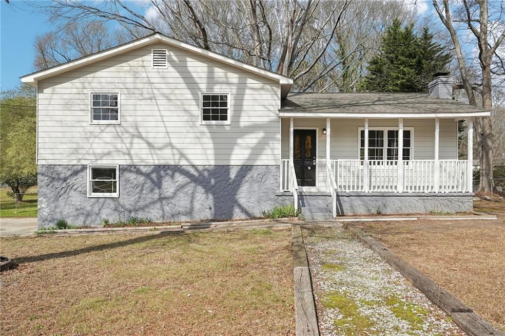 Split level home featuring a chimney, covered porc