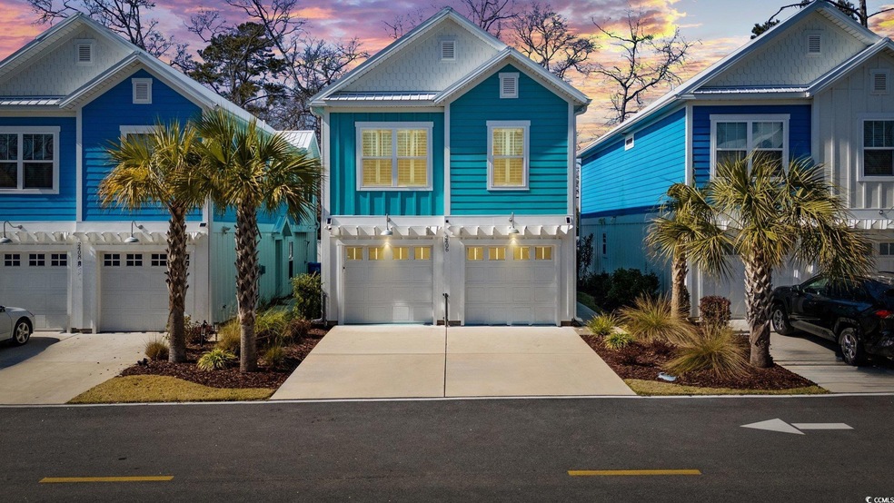 Coastal home featuring concrete driveway, an attac