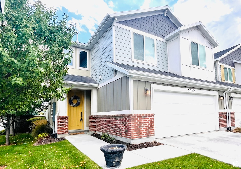 View of front of property with brick siding, an attached garage, driveway, and a shingled roof