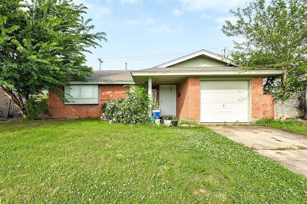 Ranch-style home with a garage and a front lawn