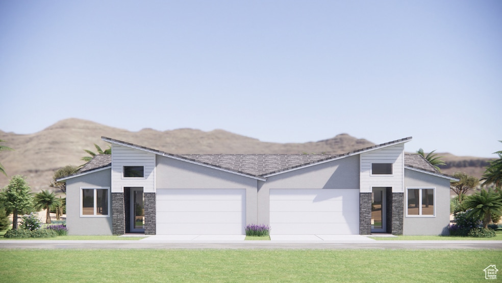 View of front of house with stone siding, a front yard, and driveway