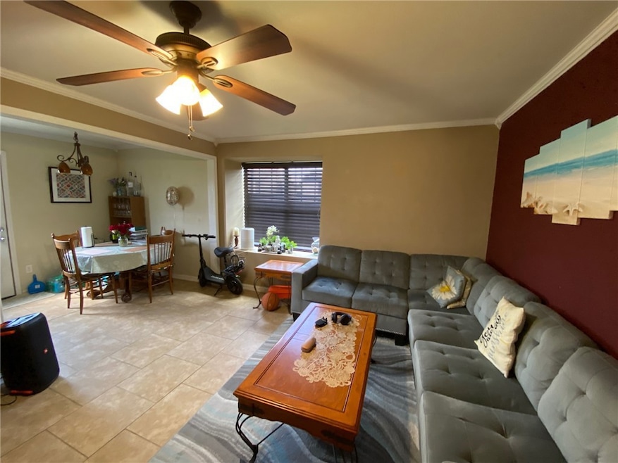 Living room featuring crown molding, a ceiling fan