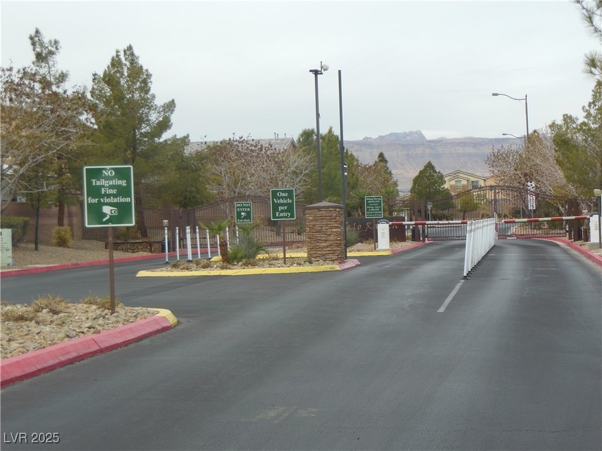 View of street with curbs, a gate, a gated entry,